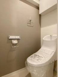 　パネル操作式の温水洗浄機能付きトイレです。吊戸棚付きでトイレ用品の収納も便利です。